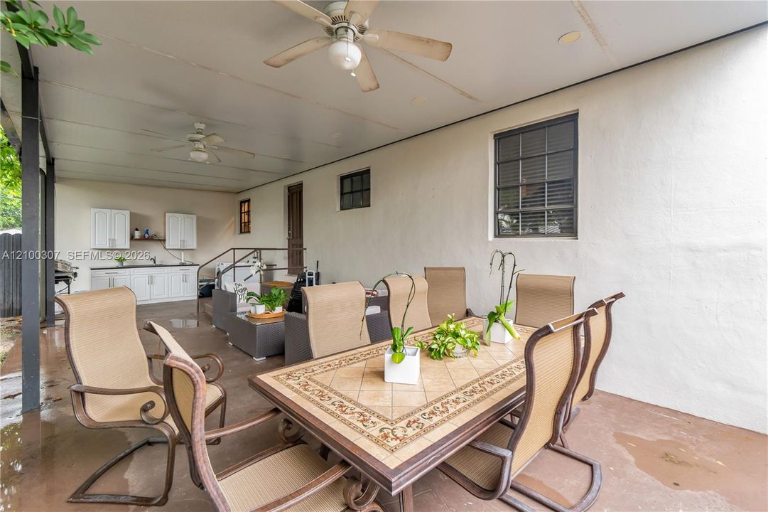 Covered patio featuring a concrete floor, built-in cabinetry, recessed lighting, and dual ceiling fans