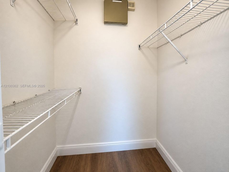 Spacious walk-in closet featuring built-in shelving and custom storage solutions.