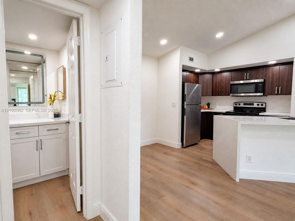 Open-concept kitchen with premium waterfall quartz counters, dark modern cabinetry, and recessed lighting.
