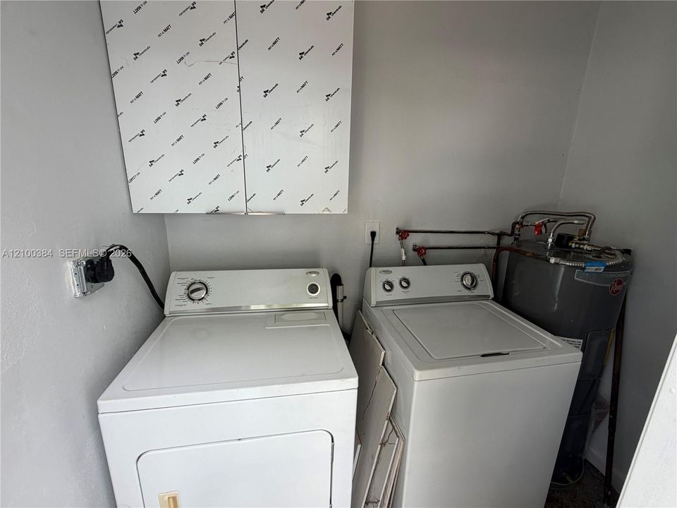 Laundry area featuring upper wall-mounted cabinetry and a standard water heater