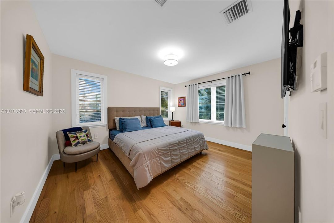 Room featuring wood-finish flooring, dual-pane windows, and a central ceiling light fixture