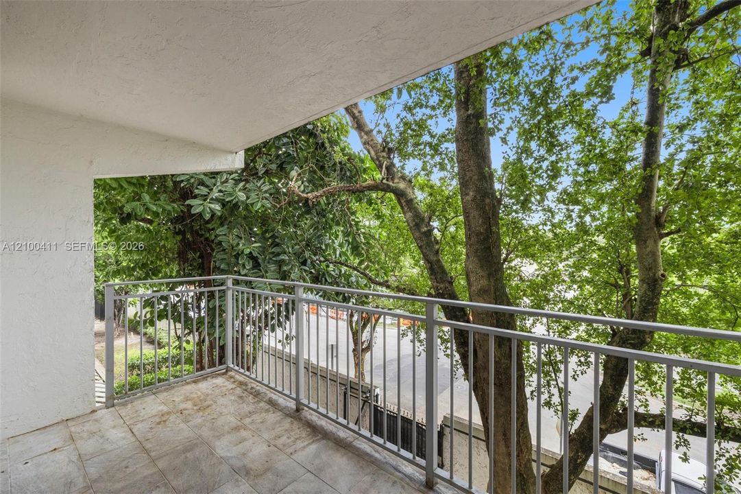 Private balcony featuring tiled flooring, a white textured ceiling, and a grey metal railing