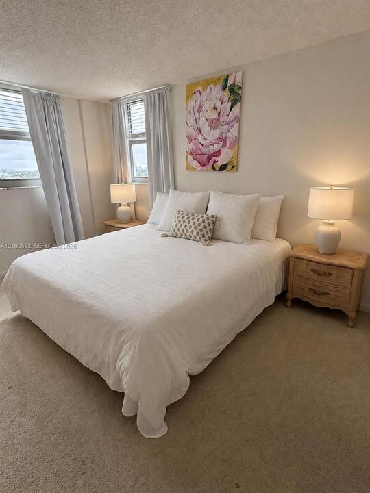 Neutral-toned room featuring wall-to-wall carpeting and multiple windows with integrated blinds