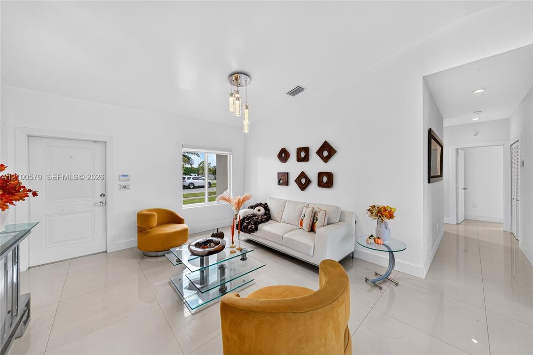 Neutral-toned tile flooring, recessed lighting, and a modern tiered glass pendant fixture