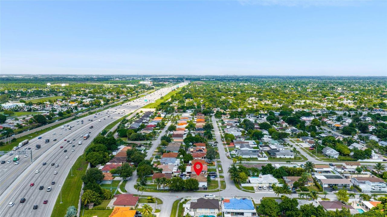 Aerial perspective of a residential property featuring a corner lot orientation, paved street access, and proximity to major regional transportation infrastructure
