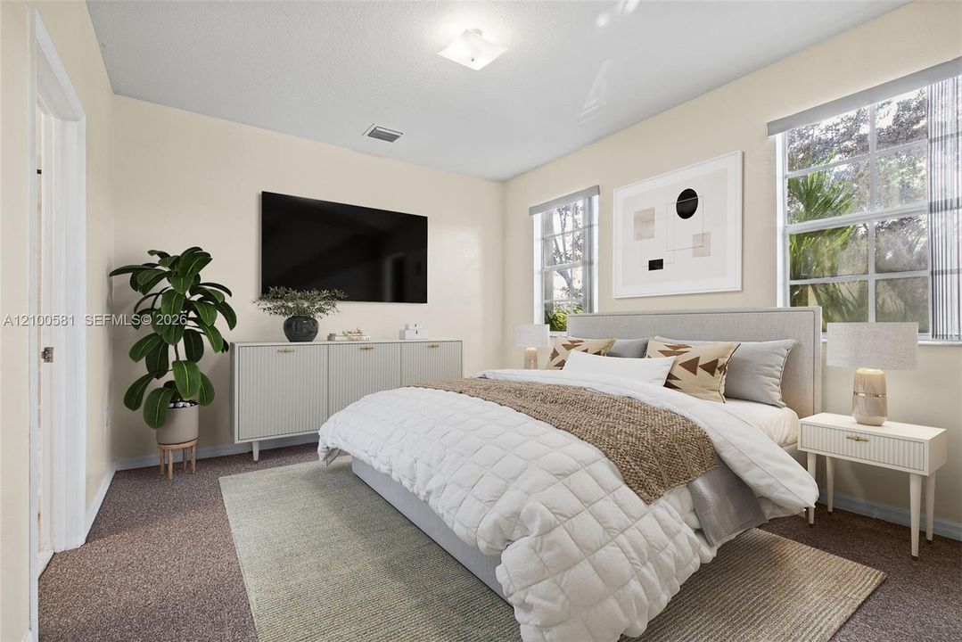 Bedroom featuring neutral wall paint, plush carpeting, dual windows, and a flush-mount ceiling light fixture