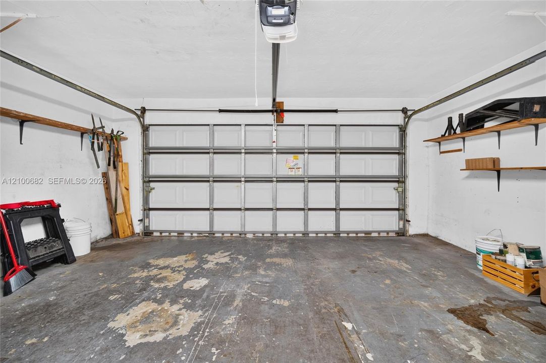 Enclosed garage featuring a newer garage door*