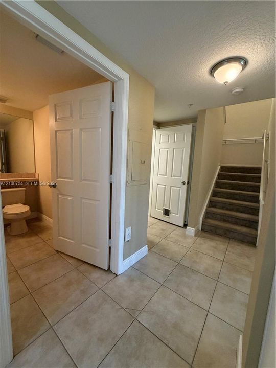 Ceramic tile flooring, carpeted stairs, flush-mount ceiling lighting, and six-panel interior doors