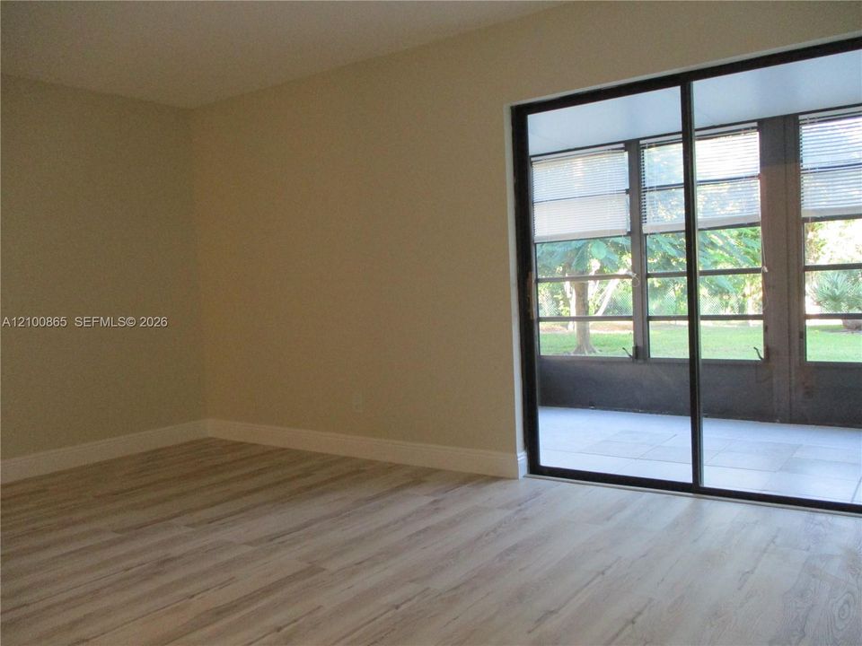Entrance from sliding door into the master bedroom. Interior space featuring wood-finish flooring, neutral wall paint