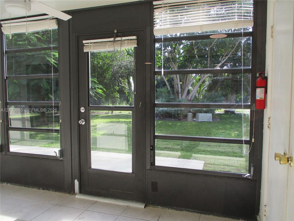 Screened enclosure with tiled flooring and a ceiling fan