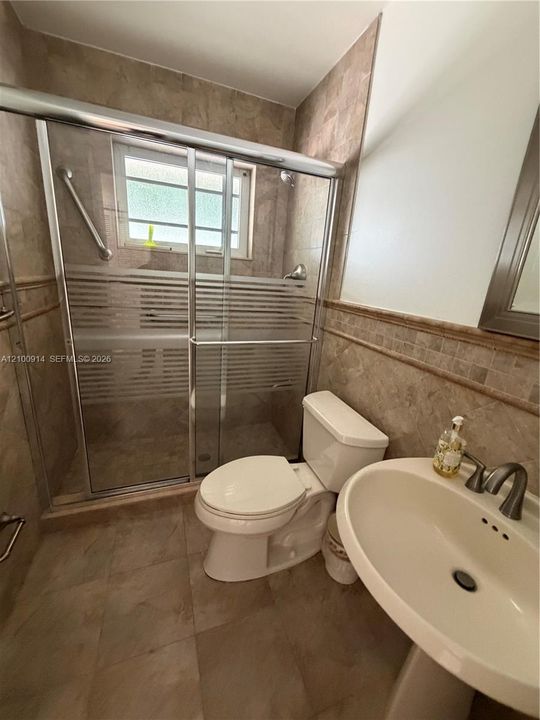 Hallway featuring ceramic tile flooring, recessed lighting, and built-in louvered closet doors