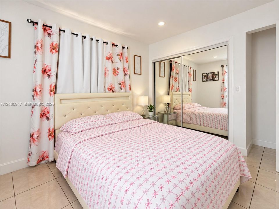 Recessed lighting, mirrored closet doors, tile flooring, and a built-in closet niche