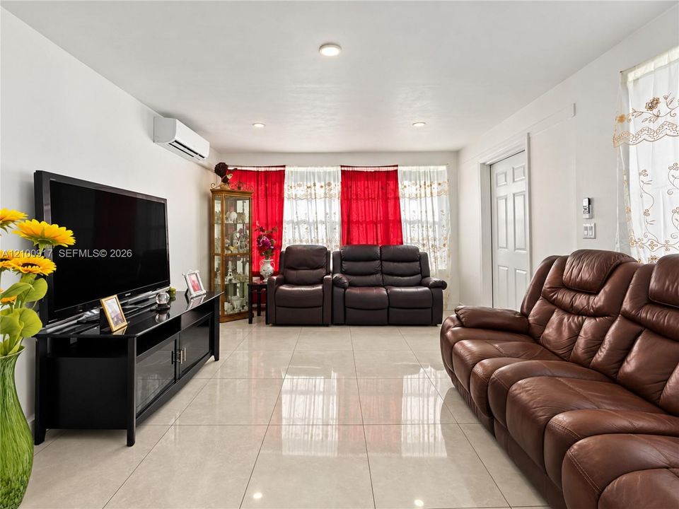 Recessed ceiling lighting, durable tile flooring, split-system air conditioning unit, and a paneled interior door