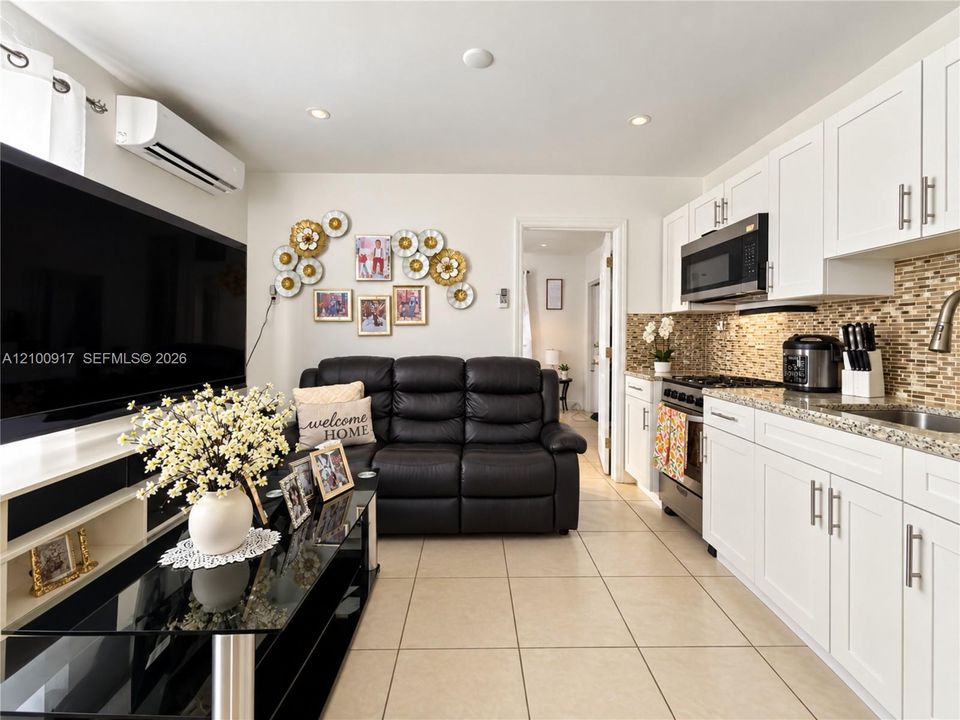 Contemporary kitchen with white cabinetry, stainless steel appliances, and a mosaic tile backsplash