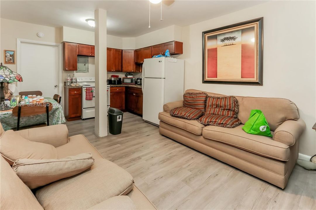 Kitchen area featuring wood-finish cabinetry, wood-finish flooring, and a central structural post