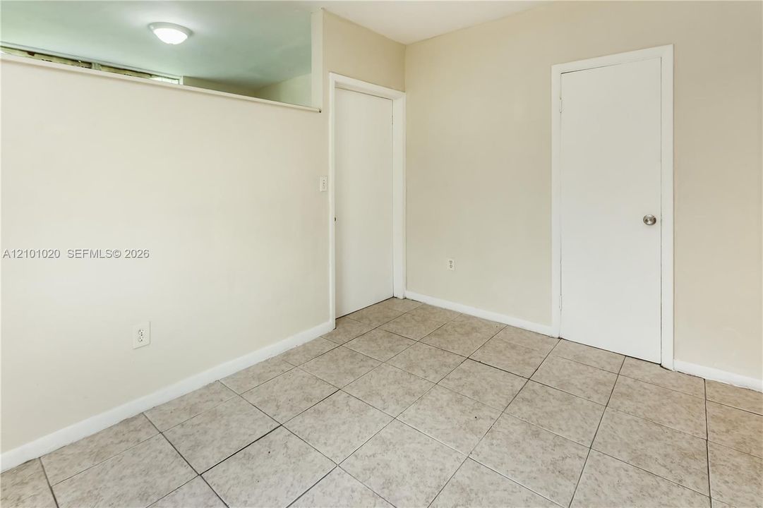 Neutral interior featuring tile flooring, smooth walls, and two solid-core interior doors