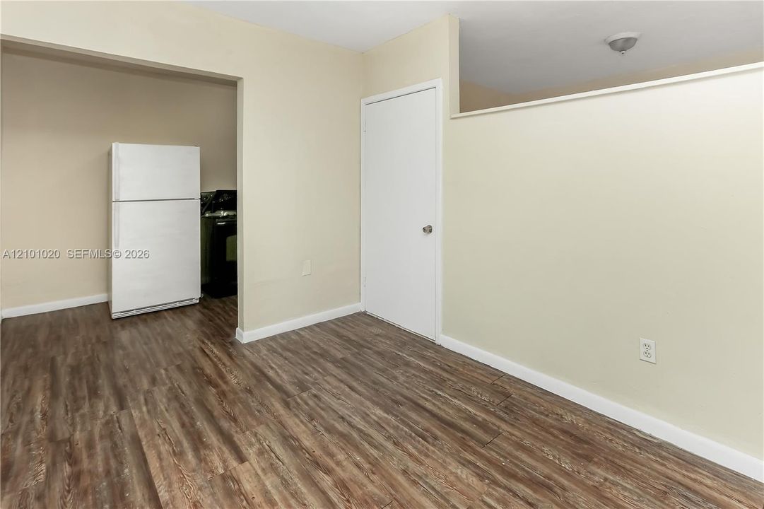 Interior space featuring wood-finish flooring, a neutral color palette, and a white interior door