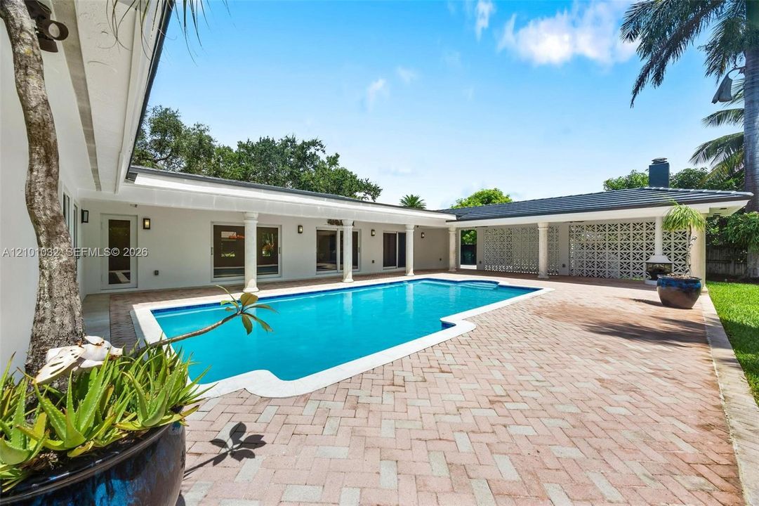Surrounded by lush greenery and connected to the outdoor living areas, the pool feels like a private retreat right at home.