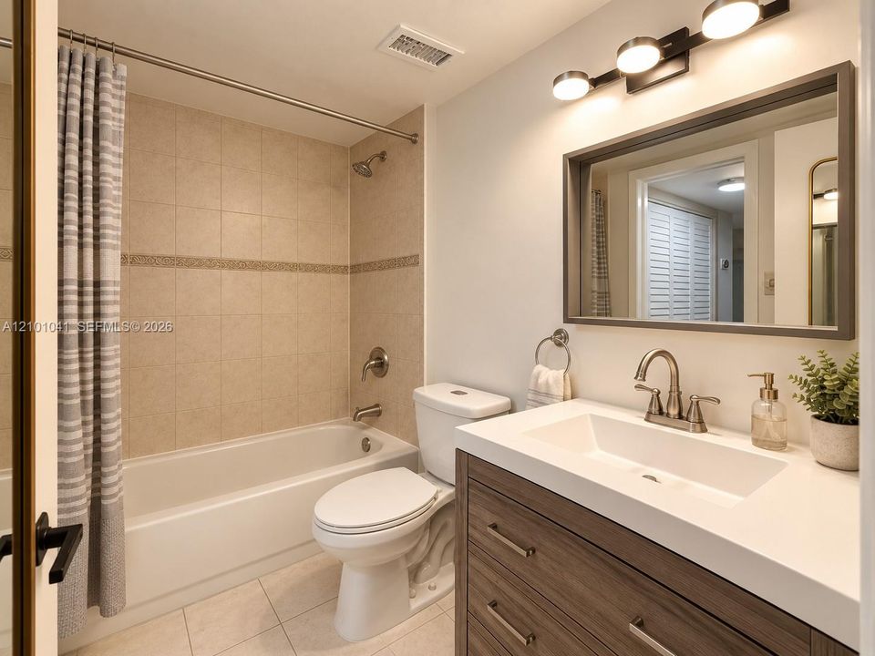 Bathroom featuring a vanity with a white composite countertop, integrated rectangular sink, and wood-finish cabinetry