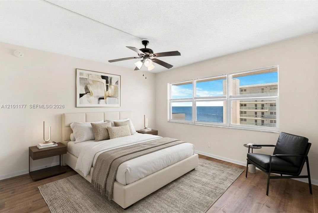 Bedroom featuring wood-finish flooring, a multi-blade ceiling fan with integrated lighting, and expansive horizontal windows