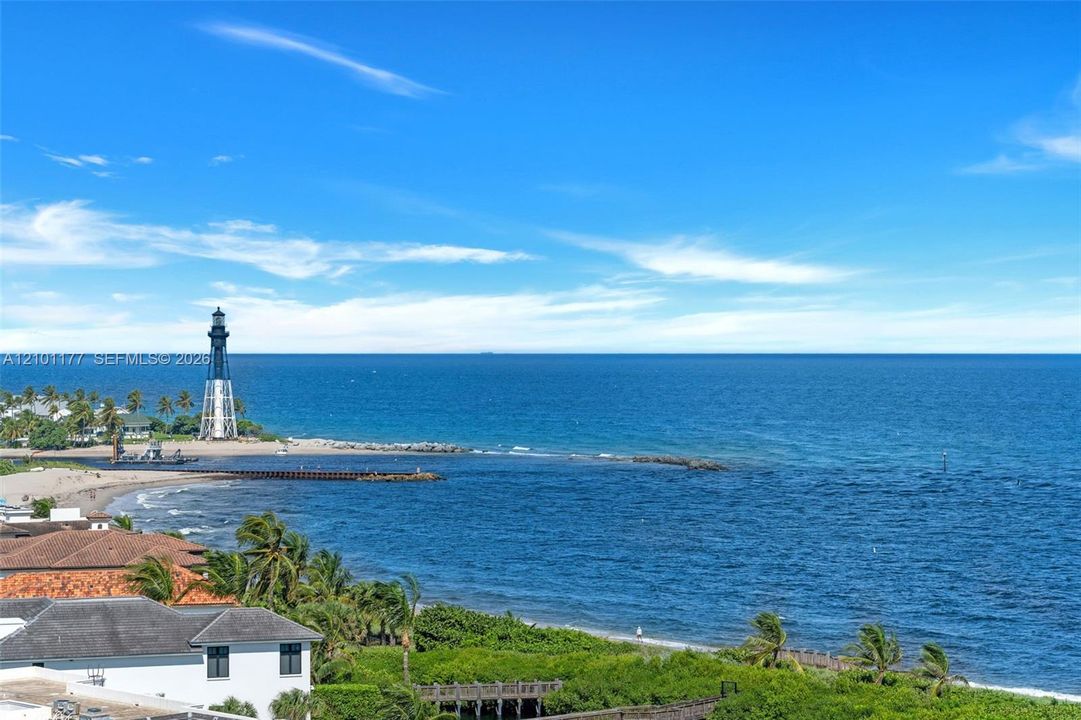 Coastal horizon featuring expansive ocean frontage, lighthouse backdrop, and tropical landscape