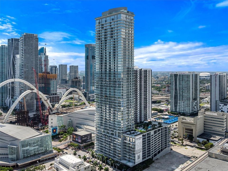 High-rise architectural tower featuring floor-to-ceiling glass paneling, a multi-level structure, private balconies, and an elevated outdoor deck