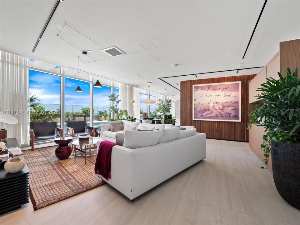 Floor-to-ceiling glass walls, wood-finish flooring, linear track lighting, and a floor-to-ceiling wood-panel feature wall