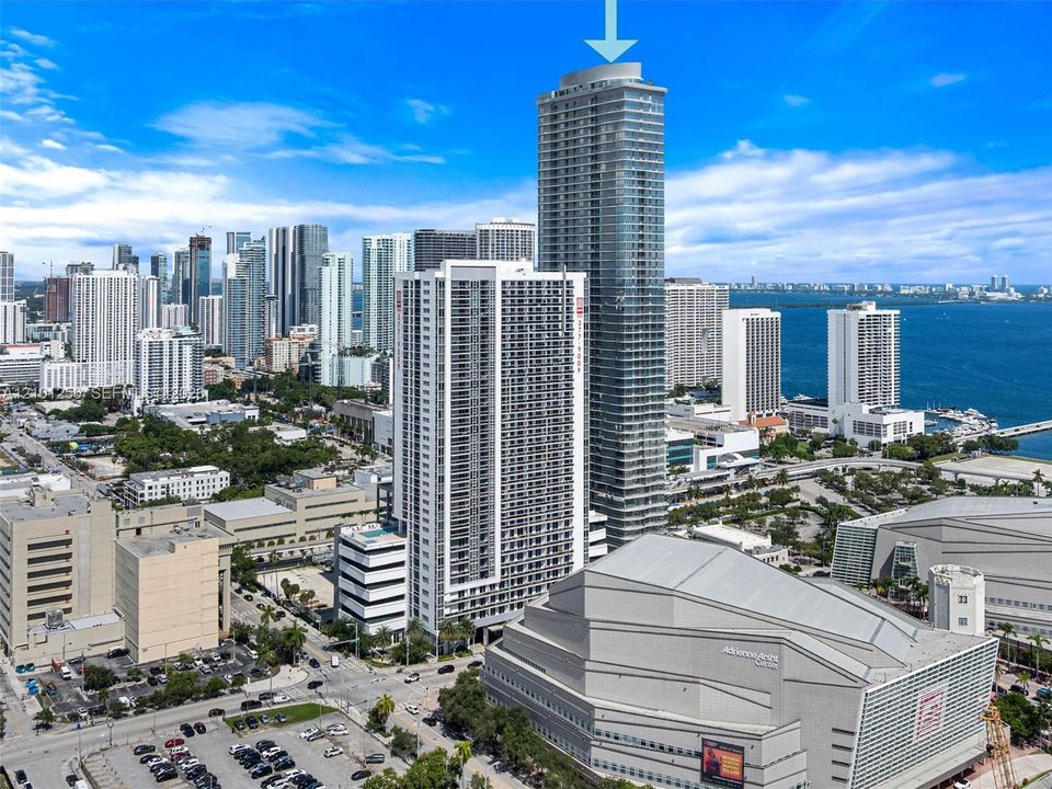 High-rise architectural structure featuring a glass facade, multiple balconies, and a prominent cylindrical crown