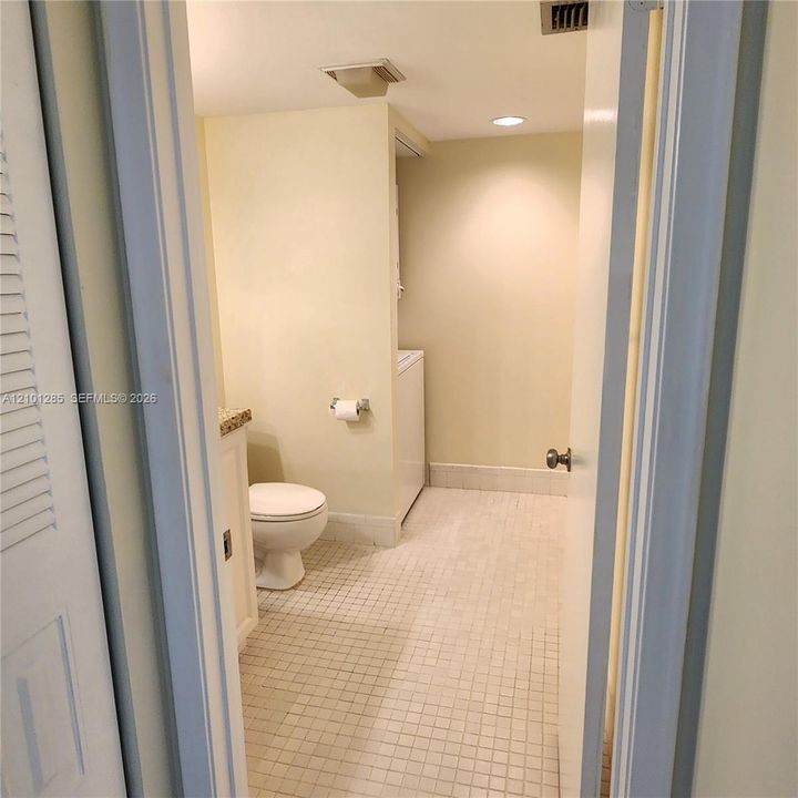Tiled flooring, vanity with stone-style countertop, porcelain toilet, and recessed lighting