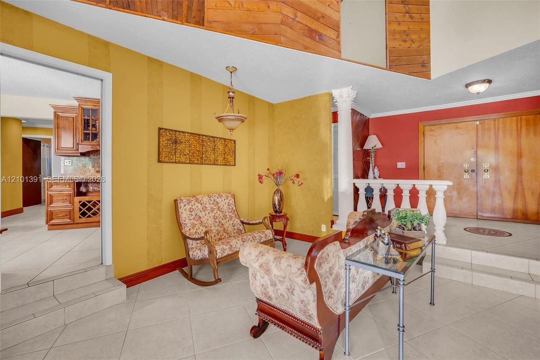 Tiled flooring, wood-paneled ceiling, decorative wall paneling, and an interior architectural column