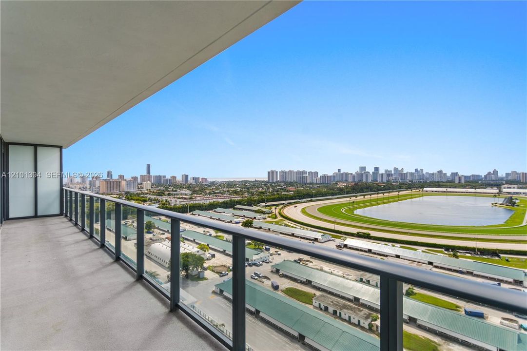 Covered balcony featuring concrete flooring and a sleek metal railing system with glass panel inserts