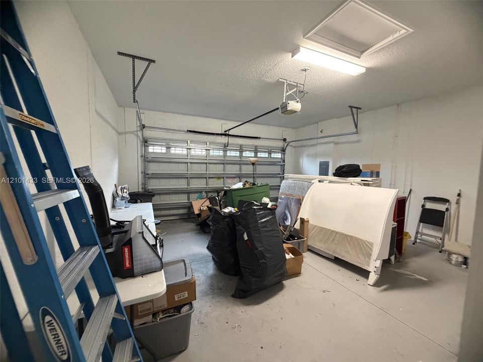 Attached garage featuring a white overhead door and painted concrete flooring
