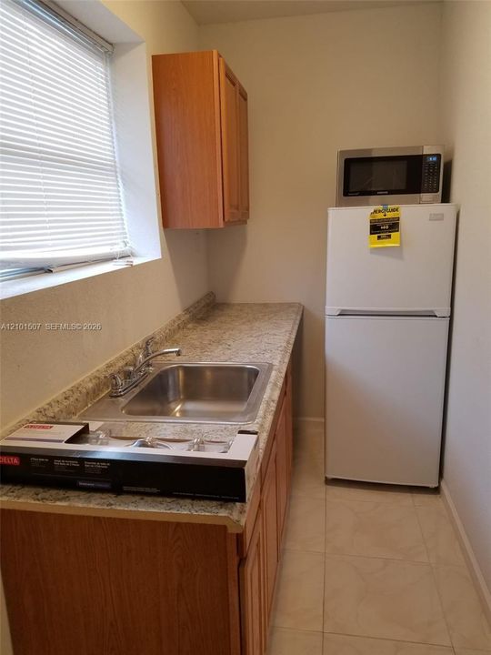Beige-floor space - sink and cabinetry