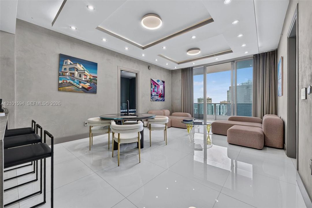Epic Residences 50th-floor living and dining area with floor-to-ceiling glass and panoramic city views.