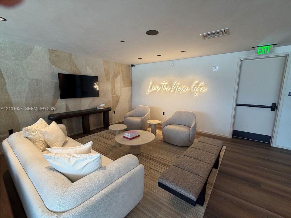 Recessed lighting, wood-finish flooring, and an accent wall featuring textured wallcovering