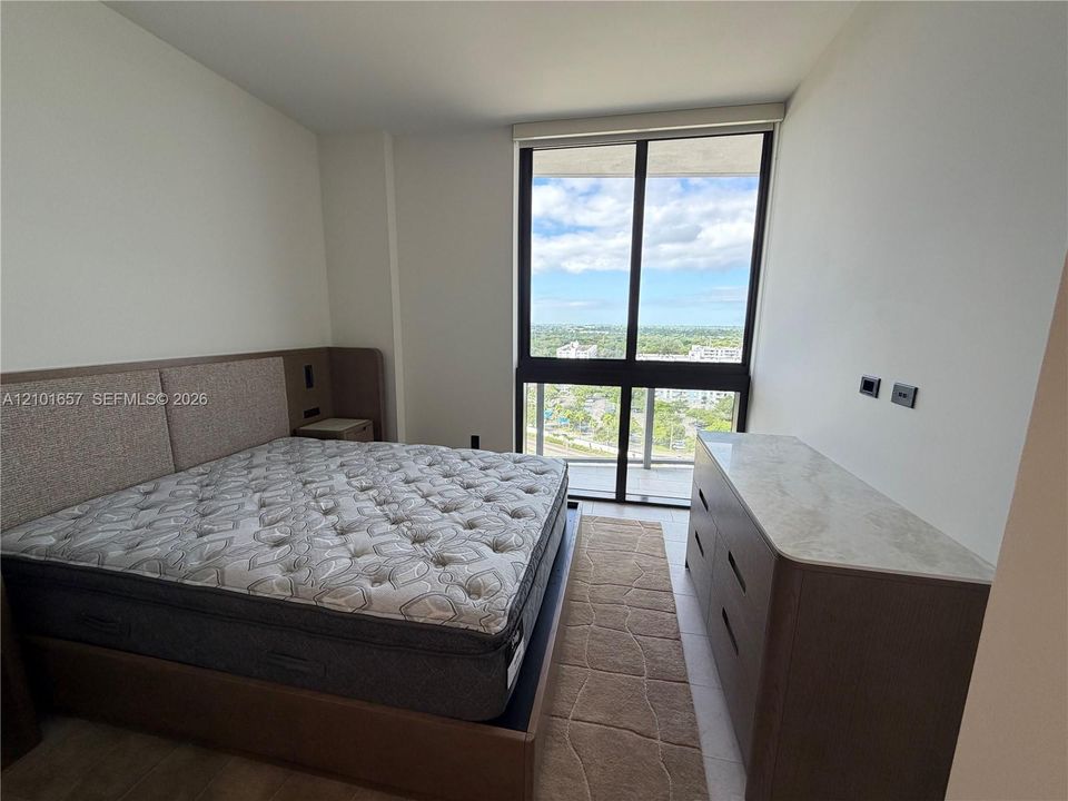 Floor-to-ceiling windows, tile flooring, and exterior balcony access
