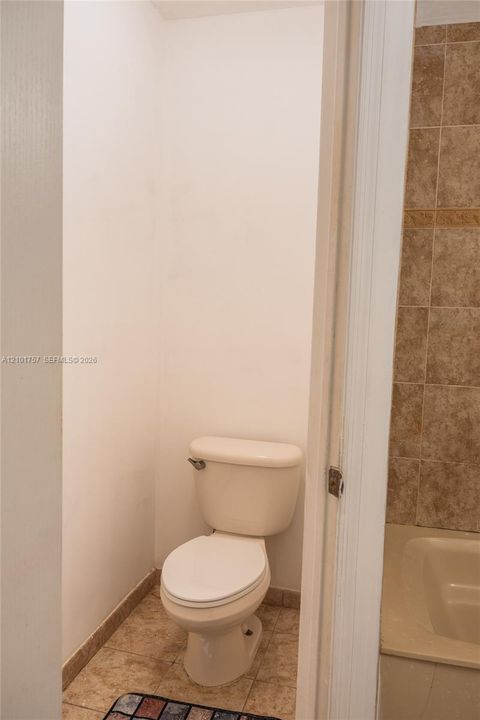 White toilet with tile flooring