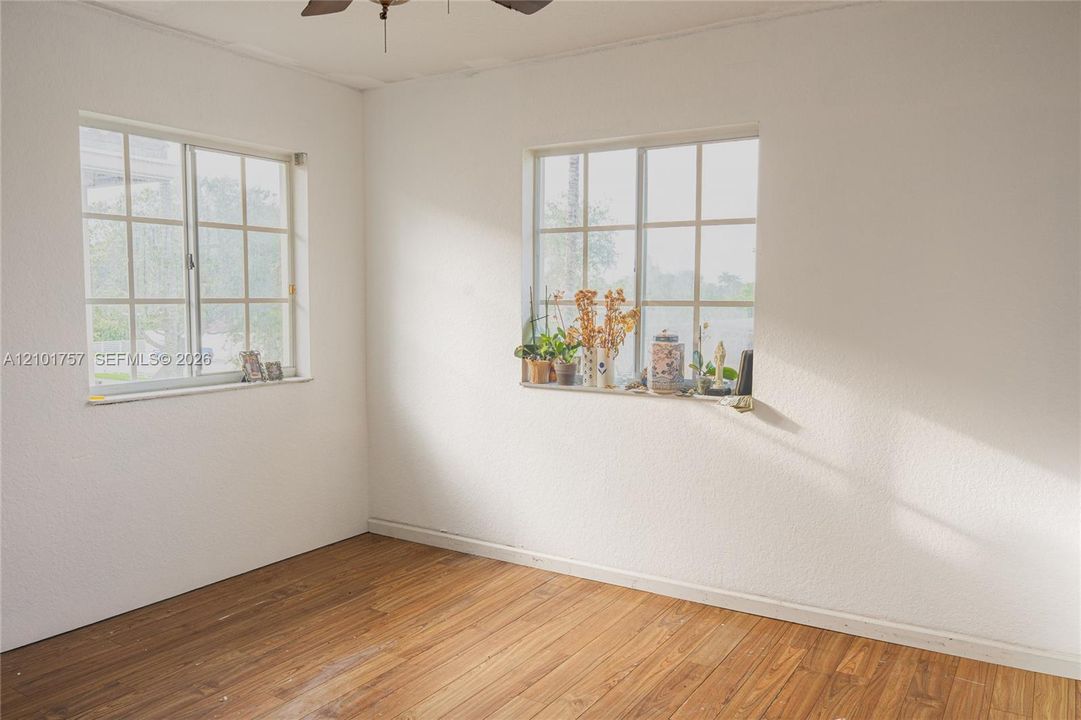Wood-finish flooring with white walls and natural light from multiple windows