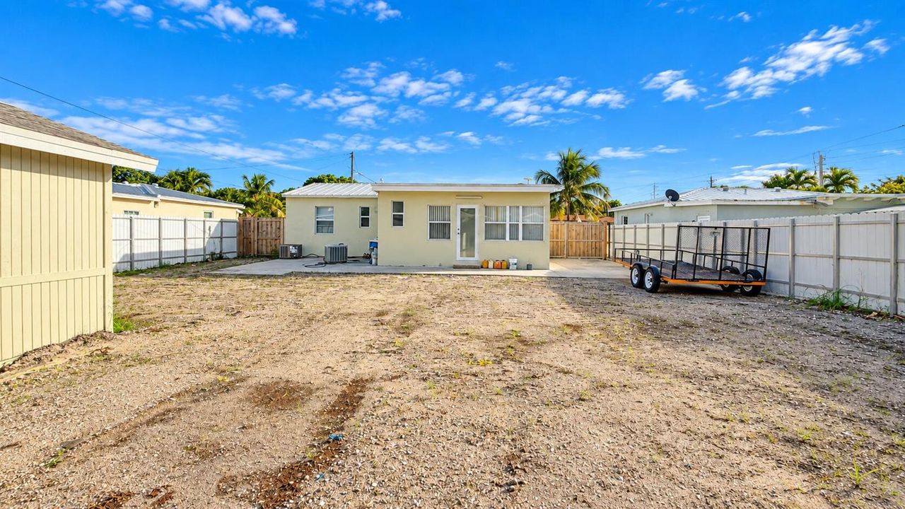Sunny Backyard with Trailer and House