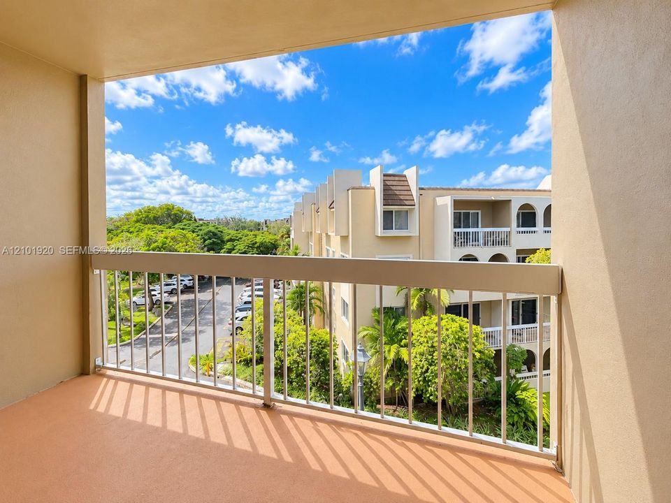 Covered balcony featuring concrete flooring and a metal railing