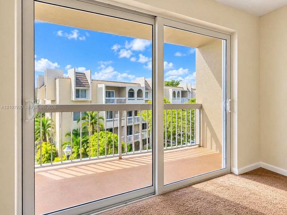 Expansive sliding glass doors opening to a private balcony with metal railing
