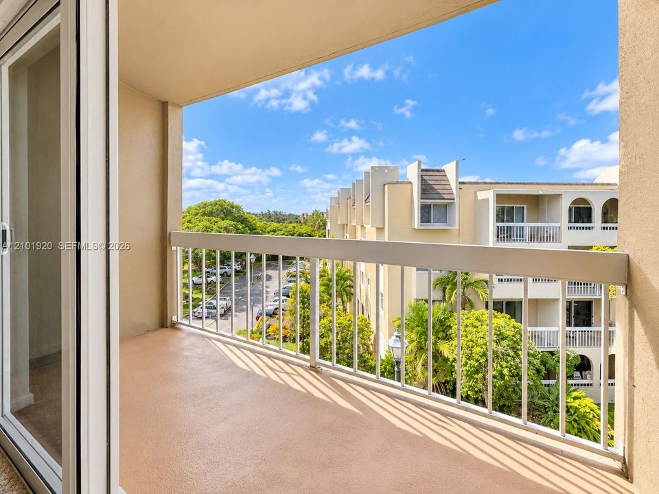 Covered balcony featuring a concrete floor surface and a white metal railing