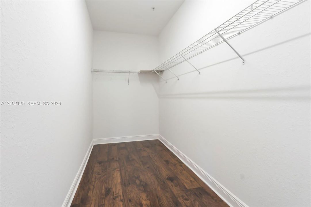 Walk-in storage space featuring wood-finish flooring will be built in closet