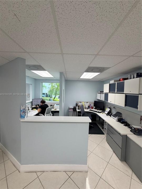 Recessed lighting, drop ceiling, tile flooring, built-in cabinetry, and a reception counter