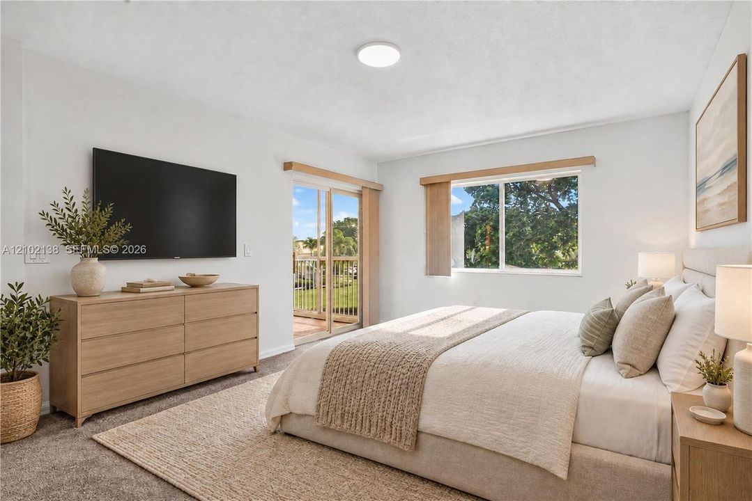 Neutral-toned interior featuring wall-to-wall carpeting, a sliding glass door with wood-finish trim, a large window with natural light, and a flush-mount ceiling light fixture