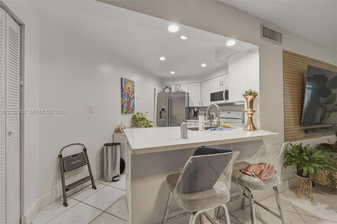 Kitchen featuring a breakfast bar, recessed lighting, and stainless steel appliances