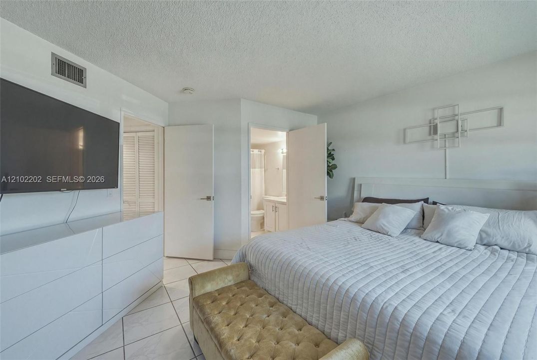 Tile flooring throughout, white interior doors, and a built-in closet with louvered doors