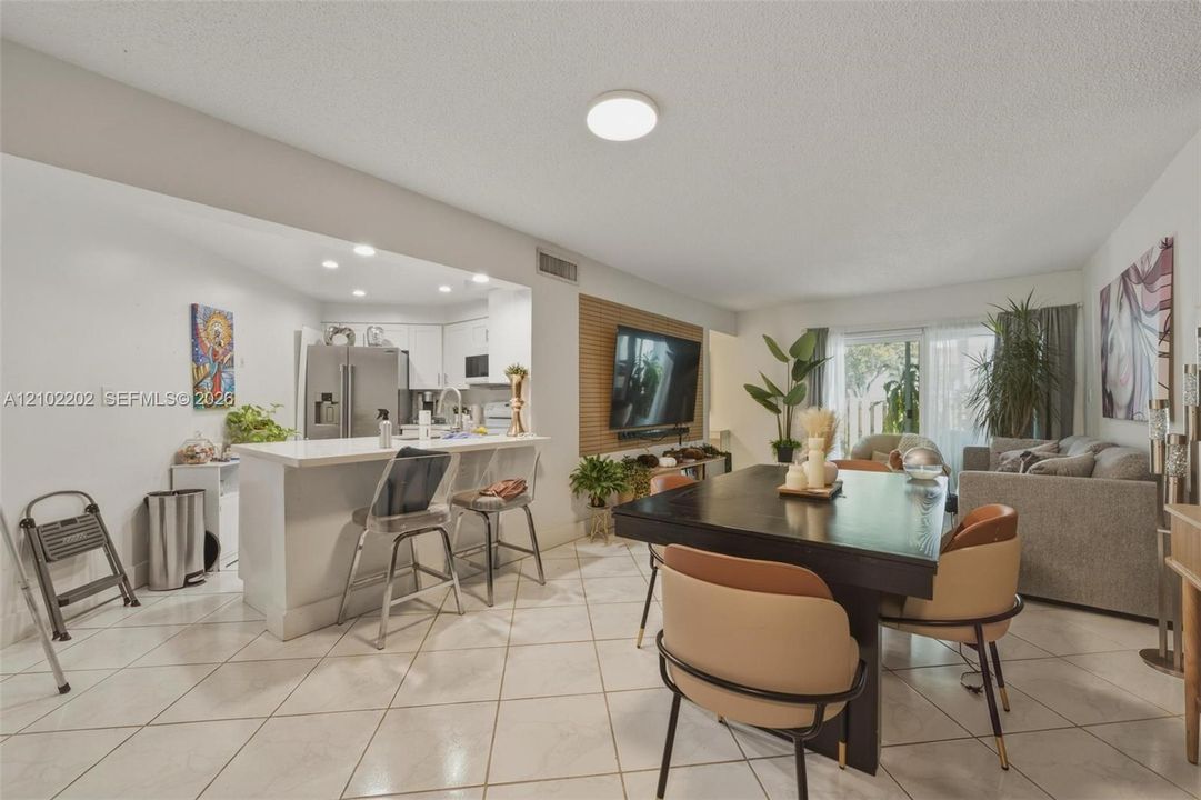 Open-concept living area with tile flooring and recessed lighting