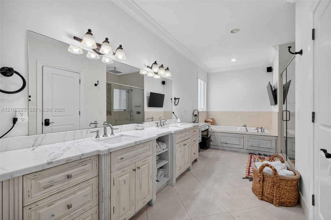A generously sized primary bath, featuring an expansive, dual sync, vanity, abundant, cabinetry, and counter space, a relaxing, soaking tub and a separate glass, enclosed shower, a beautifully appointed space design for comfort, convenience, and every day indulgence.