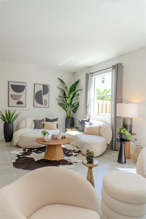 Living area featuring large-format ceramic tile flooring and a window with installed curtain rod hardware